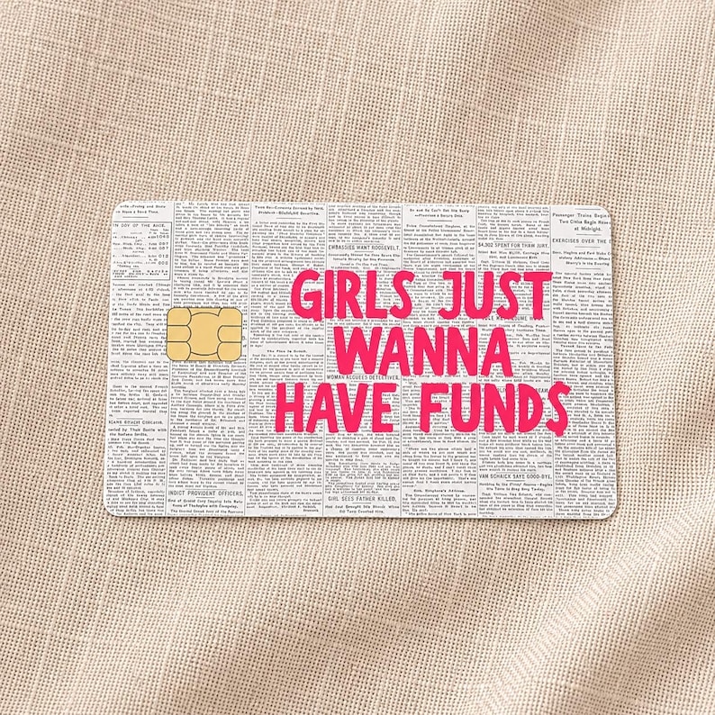 May include: A rectangular credit card skin featuring a black and white vintage newspaper print background. The text GIRLS JUST WANNA HAVE FUNDS is printed in bold, bright pink capital letters across the center. A gold chip is visible on the left.