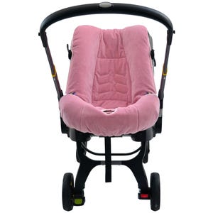 May include: A baby stroller with a pink, padded seat. The seat has a quilted design and is surrounded by a black frame. The stroller has a black handle and wheels, and is designed for infant use.