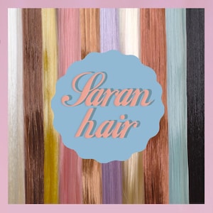 May include: A variety of colorful hair extensions in shades of blonde, pink, brown, and blue. The image features the text "Saran hair" in a light pink script on a blue background.