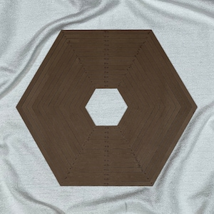 May include: A brown hexagon-shaped quilting ruler with markings in inches from 4 to 16. The ruler has a smaller hexagon in the center.