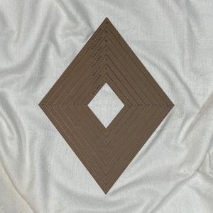 Op de afbeelding: Een set van acht bruine, ruitvormige frames van karton met afmetingen in inches. De frames zijn in elkaar genest, met het kleinste frame in het midden.