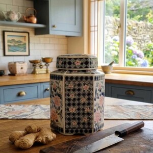 Peut inclure: Un pot à gingembre hexagonal en céramique avec couvercle, orné d'un motif géométrique en treillis bleu foncé et blanc, superposé de motifs floraux roses et orange ainsi que de petits oiseaux bleus, posé sur une surface en bois près de gingembre.