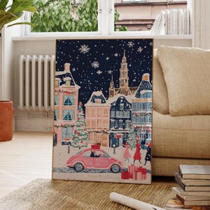 May include: A pink car drives through a snowy European town at night. The car is decorated with a Christmas tree and presents. The town is lit up with Christmas lights and there are people walking around.