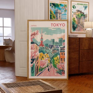 May include: Three framed travel posters with colorful illustrations of cityscapes. The posters are titled "Lisbon", "Edinburgh", and "Tokyo". The Tokyo poster features a pink and green cityscape with a tall tower in the center.