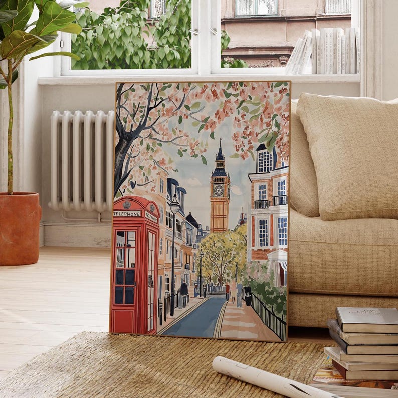 May include: A colorful illustration of a London street scene with a red telephone booth, a clock tower, and blooming cherry blossom trees. The street is lined with buildings and has a cobblestone road.