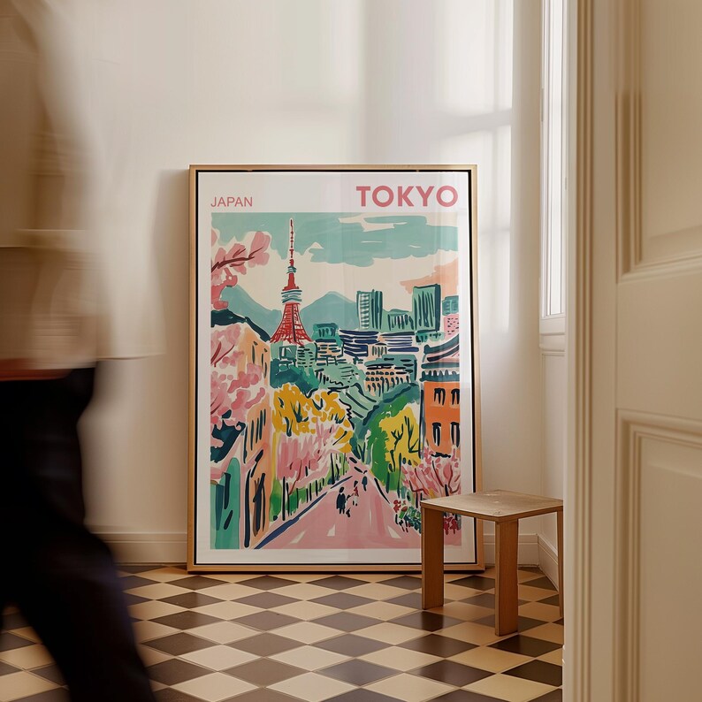 May include: A framed poster with a colorful illustration of Tokyo, Japan. The poster features a cityscape with a tall tower, trees, and buildings. The text "JAPAN" and "TOKYO" is printed at the top of the poster.