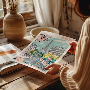 May include: A colorful illustration of the Eiffel Tower in Paris, France. The illustration features a blue sky, pink cherry blossoms, and a street scene with buildings and trees. The text "France" and "Paris" is included in the illustration.