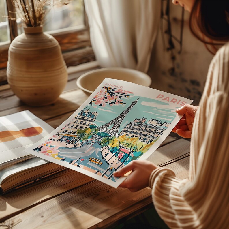 May include: A colorful illustration of the Eiffel Tower in Paris, France. The illustration features a blue sky, pink cherry blossoms, and a street scene with buildings and trees. The text "France" and "Paris" is included in the illustration.