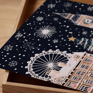 May include: A dark blue Christmas card with a snowy night scene of London landmarks. The London Eye, Big Ben, and a Christmas tree are depicted in white against a dark blue background with white snowflakes.