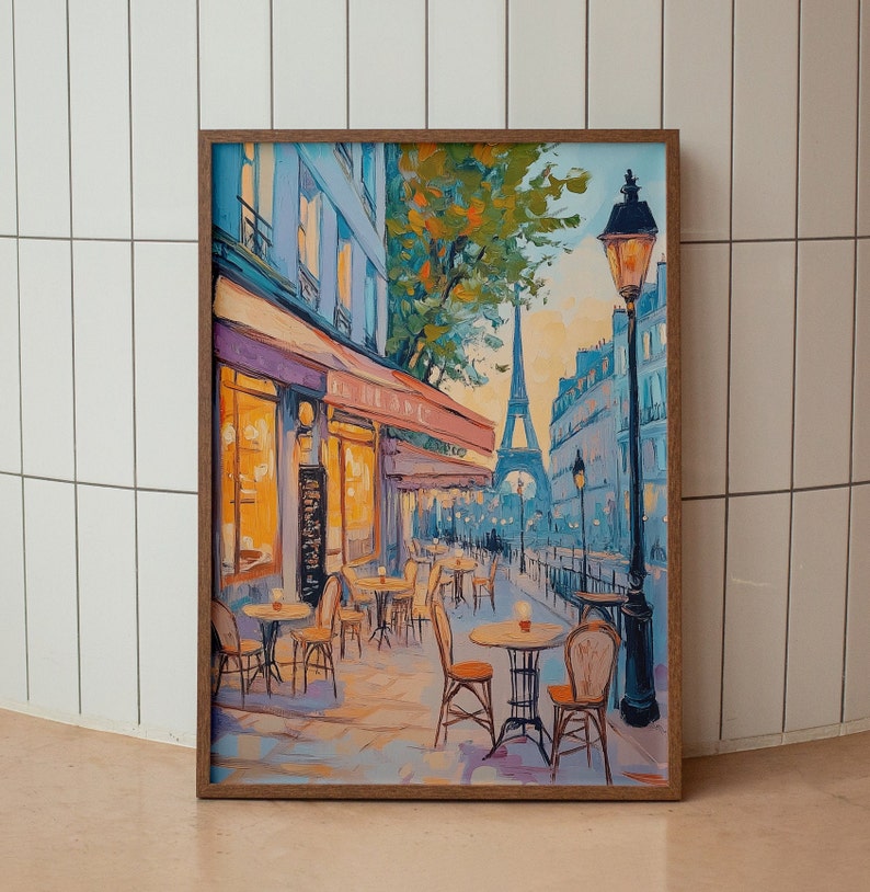 May include: A painting of a Parisian cafe with tables and chairs set up outside. The Eiffel Tower is visible in the background, and a street lamp stands tall on the right side of the painting. The cafe is painted in a warm, inviting style, with a yellow awning and a bright blue sky.