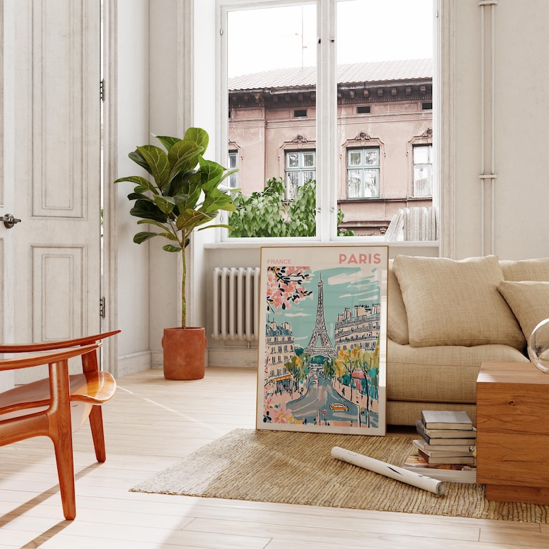 May include: A framed poster with a colorful illustration of the Eiffel Tower in Paris, France. The poster is hanging on a white wall in a living room setting.