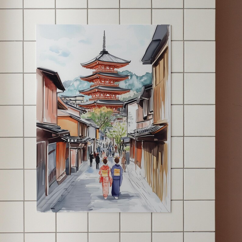 May include: Watercolor painting of a Japanese street scene. A multi-tiered red pagoda stands in the background, with buildings lining a cobblestone street. Two figures in traditional dress walk towards the viewer. The artwork is framed and mounted on a white tiled wall.