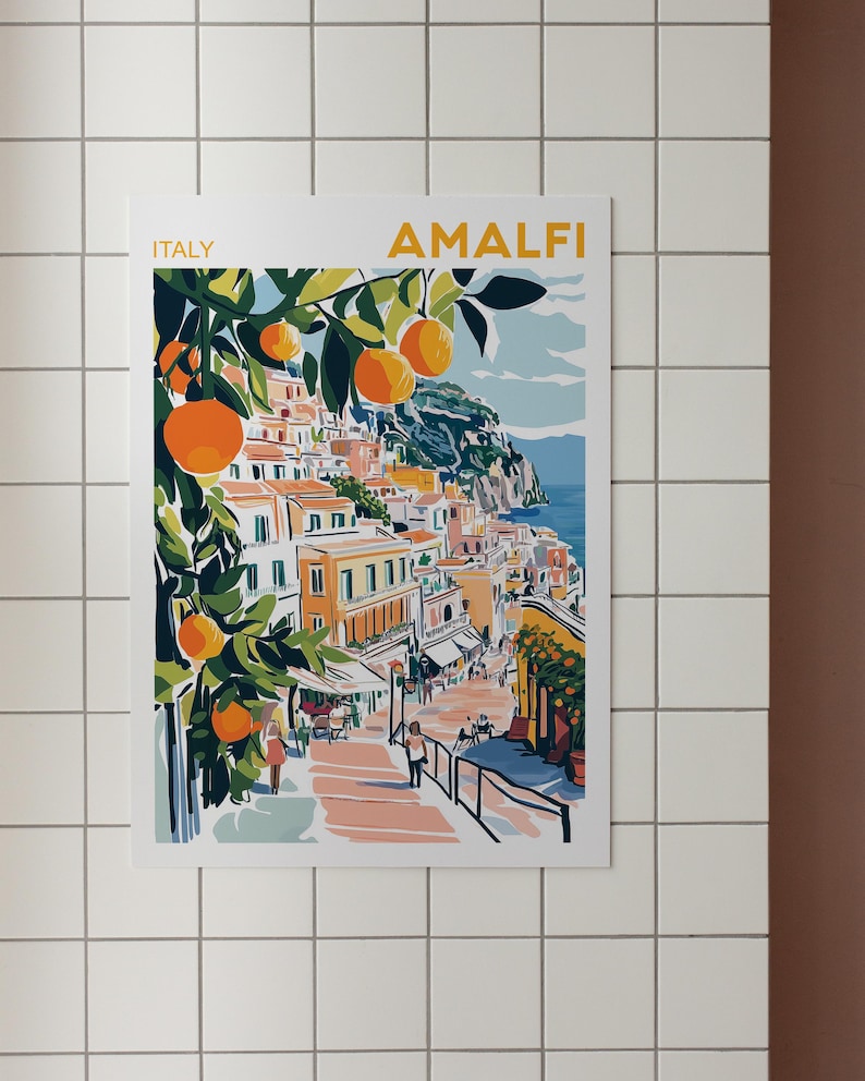 May include: A colorful illustration of the Amalfi Coast in Italy, featuring a hillside town with buildings, a winding road, and a lush orange tree with ripe fruit. The text "ITALY" and "AMALFI" are visible at the top of the image.
