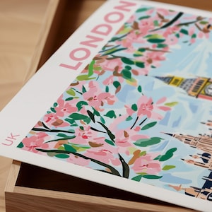 Peut inclure: Une illustration color&eacute;e de Londres, Royaume-Uni, avec des fleurs roses au premier plan et les Chambres du Parlement et Big Ben en arri&egrave;re-plan.