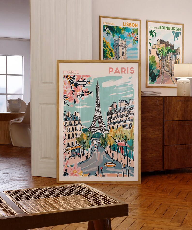 May include: A set of four framed cityscapes featuring illustrations of Lisbon, Edinburgh, Paris, and France. The Paris illustration features the Eiffel Tower and a street scene with pink cherry blossoms.