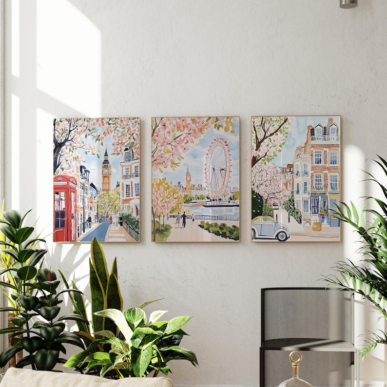 May include: Three watercolor paintings depicting scenes from London, England. The first painting shows a red telephone booth and a street lined with buildings. The second painting shows the London Eye Ferris wheel and a river with cherry blossoms. The third painting shows a street with a blue car and a building with a red door.