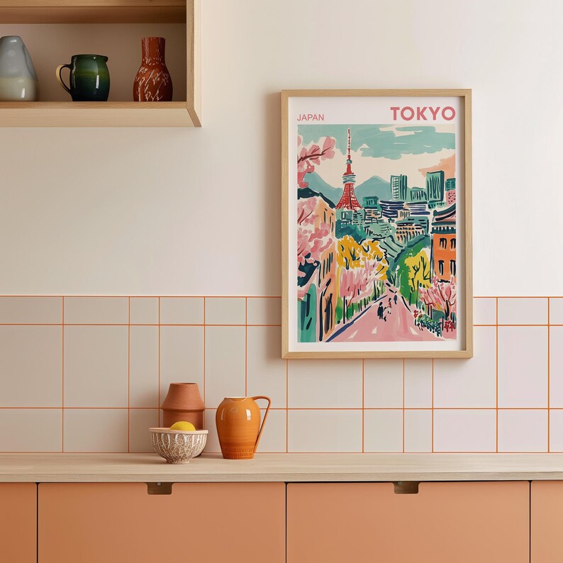 May include: A framed print of a colorful illustration of Tokyo, Japan. The print features a cityscape with a tower, trees, and buildings. The text "JAPAN" and "TOKYO" is printed at the top of the print.