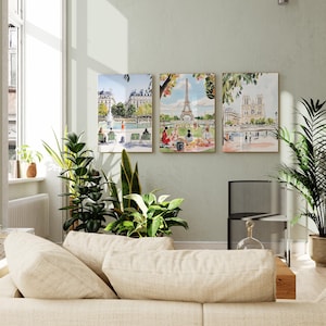 May include: Three watercolor paintings of Parisian landmarks. The first painting shows a fountain in a park with people sitting on benches. The second painting shows the Eiffel Tower with people picnicking in the foreground. The third painting shows the Notre Dame Cathedral with people walking along the Seine River.