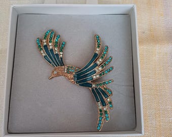 以下が含まれることがあります： 緑と白のクリスタルアクセントが付いた鳥の形をしたゴールドトーンのブローチ