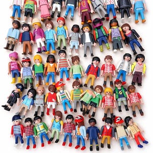 May include: A group of colourful toy figures, each with distinct outfits and hairstyles. The figures are dressed in various combinations of shirts, trousers, and jackets, with a variety of skin tones and hair colours. Some figures are wearing hats.