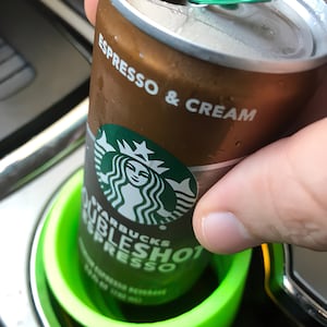 May include: A can of Starbucks DoubleShot Espresso & Cream, with a green pull tab, in a green cup holder.