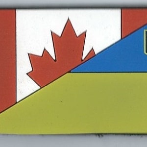 May include: A patch with the Canadian flag and the Ukrainian flag. The Canadian flag is red and white with a maple leaf. The Ukrainian flag is blue and yellow with a trident.