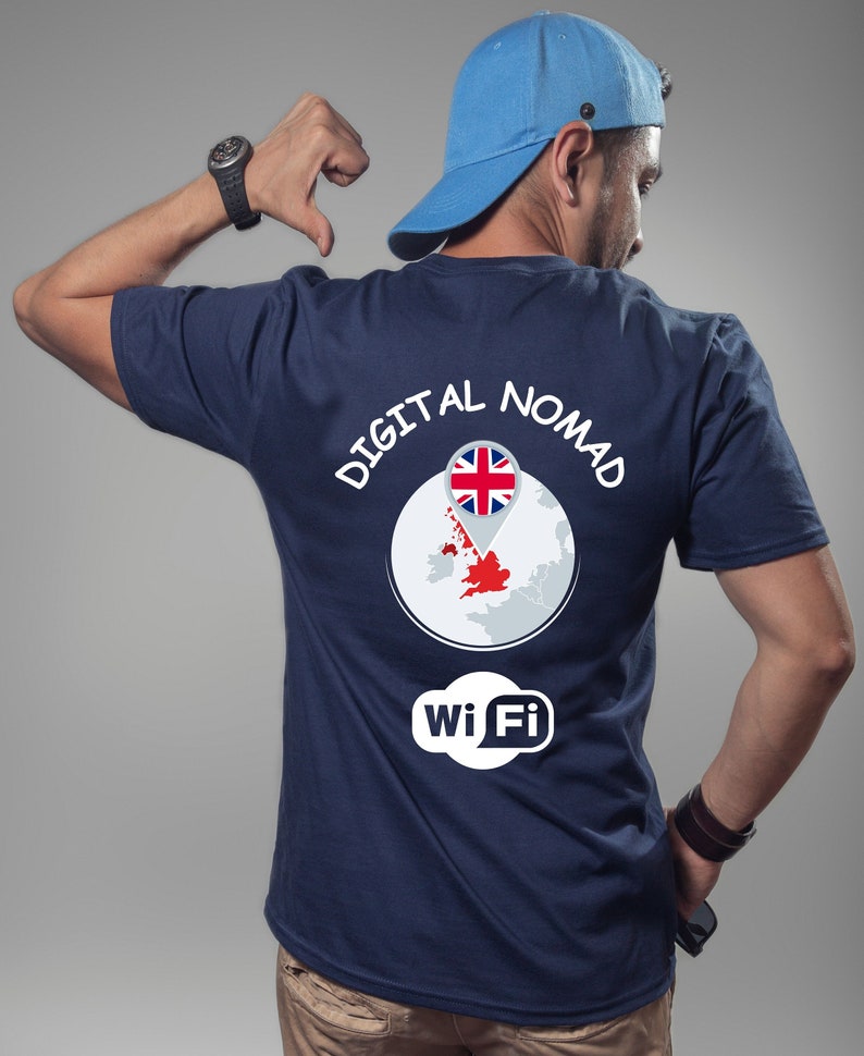 Op de afbeelding: Een donkerblauw T-shirt met de tekst "DIGITAL NOMAD" gedrukt op de achterkant. Het ontwerp bevat een wereldbol met een pin die naar het Verenigd Koninkrijk wijst en de tekst "wi Fi" in een wolkvorm.