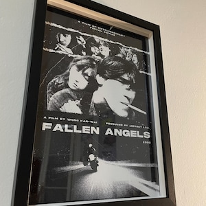 May include: A black and white film poster for the movie "Fallen Angels" directed by Wong Kar-wai. The poster features a motorcycle driving down a road with a group of people in the background. The text "A film of extraordinary visual power" is at the top of the poster.