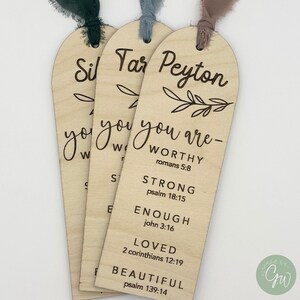 May include: Three wooden bookmarks with a leafy design and the words "you are" followed by a list of positive affirmations and bible verses. The names "Sil", "Tar", and "Peyton" are at the top of each bookmark.
