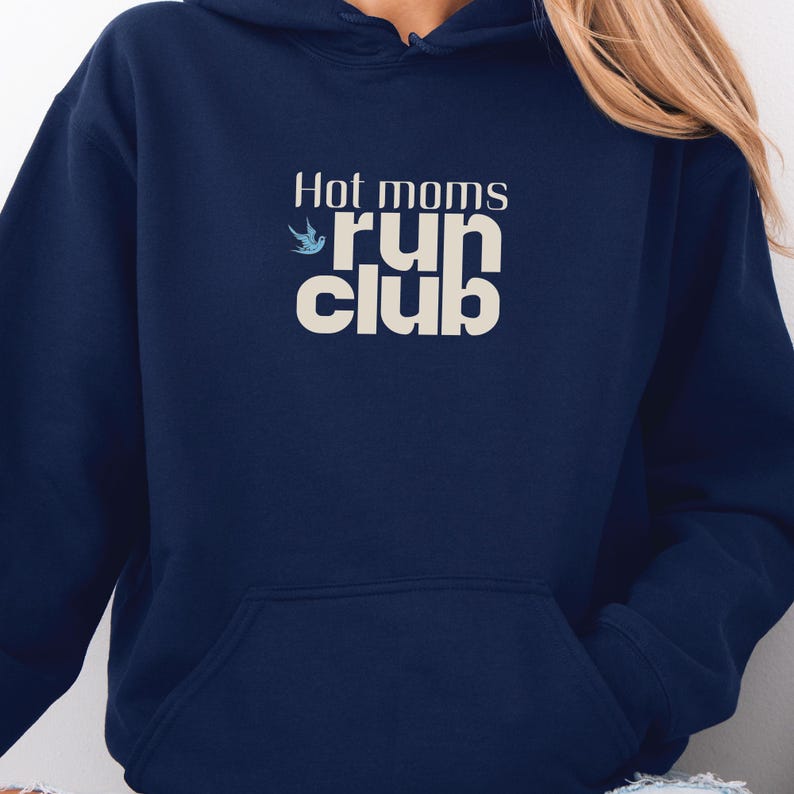 May include: Navy blue hoodie with the text "Hot moms run club" in white and teal. The hoodie has a front pocket and a hood. The text is in a stylized font.