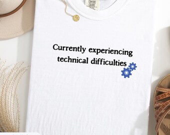 Könnte beinhalten: Weißes T-Shirt mit dem Text "Currently experiencing technical difficulties" und einem blauen Zahnrad-Symbol.