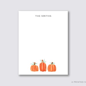 May include: A white notepad with the text "THE SMITHS" at the top. Three orange pumpkins with green stems are at the bottom of the notepad.
