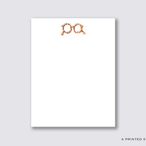 May include: A white notepad with a leopard print glasses design at the top. The notepad is blank and ready for writing.