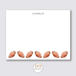 May include: White notepad with the name "CHARLIE" at the top. The bottom of the notepad features a row of watercolor-style footballs. The logo for "PRINTED SPECTACLE" is at the bottom.