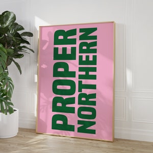 Könnte beinhalten: Ein rosa gerahmtes Poster mit den Worten "PROPER NORTHERN" in fetten, grünen Buchstaben.