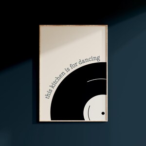 Może przedstawiać: Czarno-biały wydruk z tekstem "this kitchen is for dancing" w łuku koła wok&oacute;ł czarnej płyty winylowej.