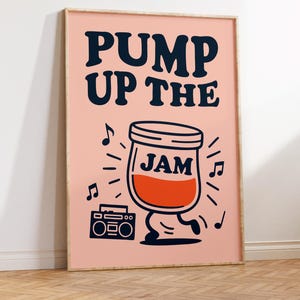 May include: A framed art print with a pink background and the words "PUMP UP THE JAM" in navy blue. A cartoon jar of jam with legs dances next to a boombox, surrounded by musical notes.