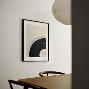 Może przedstawiać: Czarno-biały wydruk w ramie z tekstem "this kitchen is for dancing" i grafiką czarnej płyty winylowej.