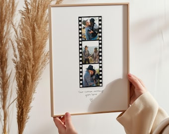 May include: A framed print featuring three photographs arranged in a film strip design. The photos show couples in various outdoor settings. The frame is a light wood color, and the background is white. The text "Your custom message goes here" is written below the film strip.