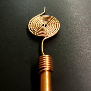 Single copper antenna top detail showing Tesla spiral and handmade finish