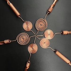 Single copper antenna standing upright on dark surface highlighting elegant finish