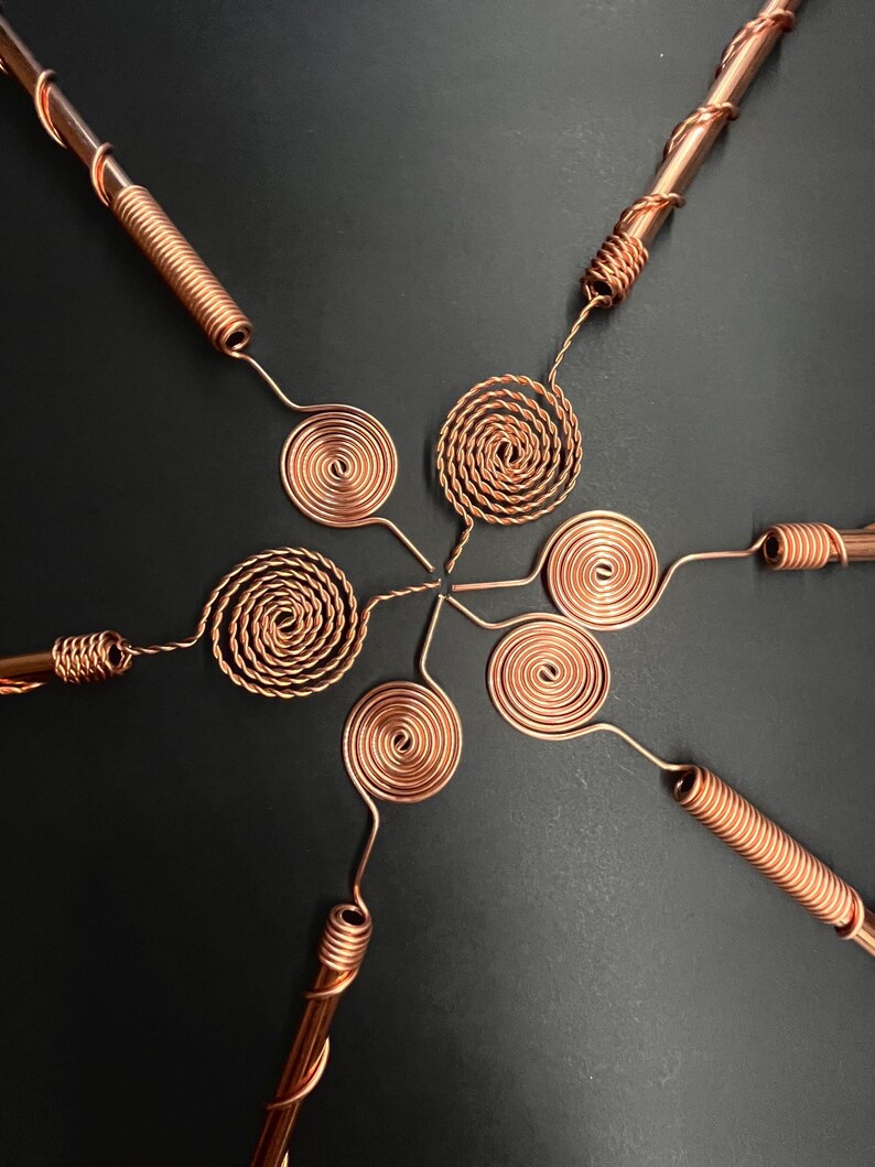 Single copper antenna standing upright on dark surface highlighting elegant finish