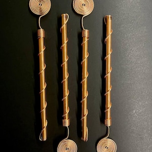 Four pure copper electroculture antennas laid side-by-side for product showcase