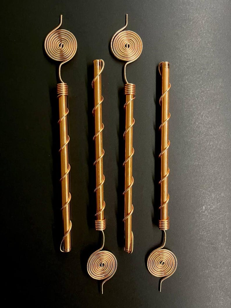 Four pure copper electroculture antennas laid side-by-side for product showcase