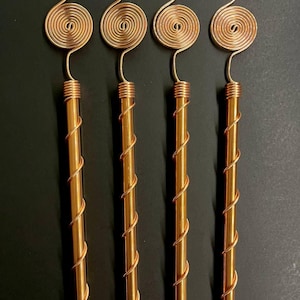 Copper antennas grouped together on dark surface for size and shape comparison
