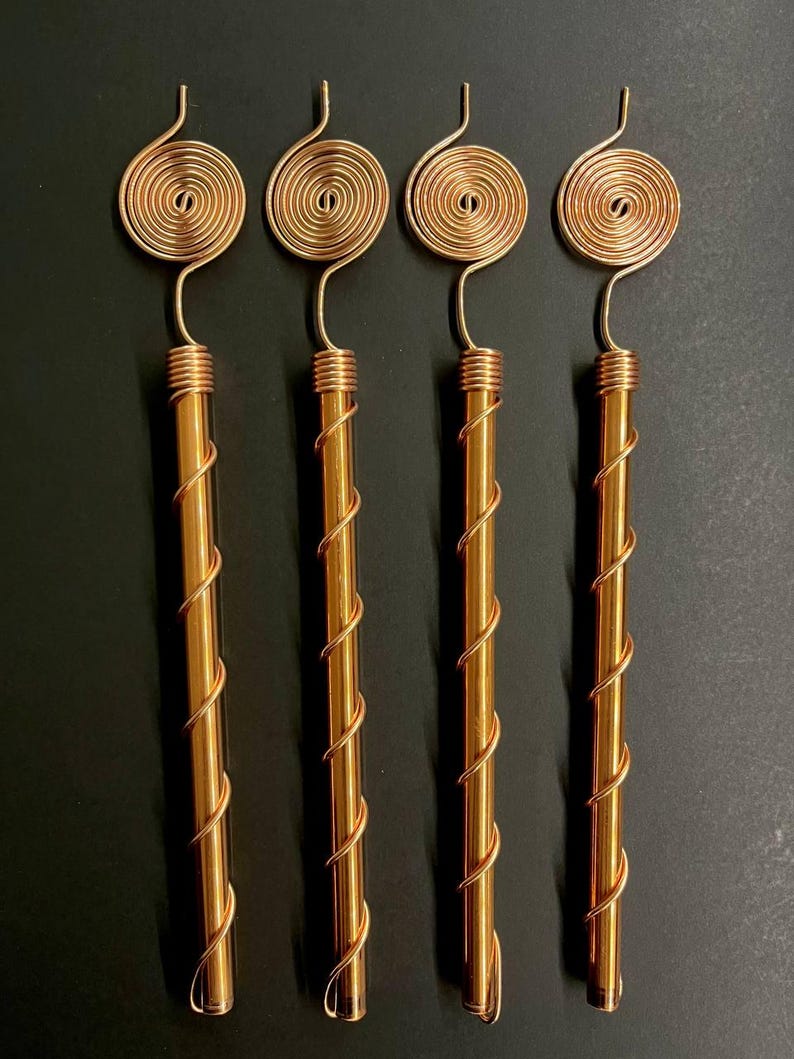 Copper antennas grouped together on dark surface for size and shape comparison