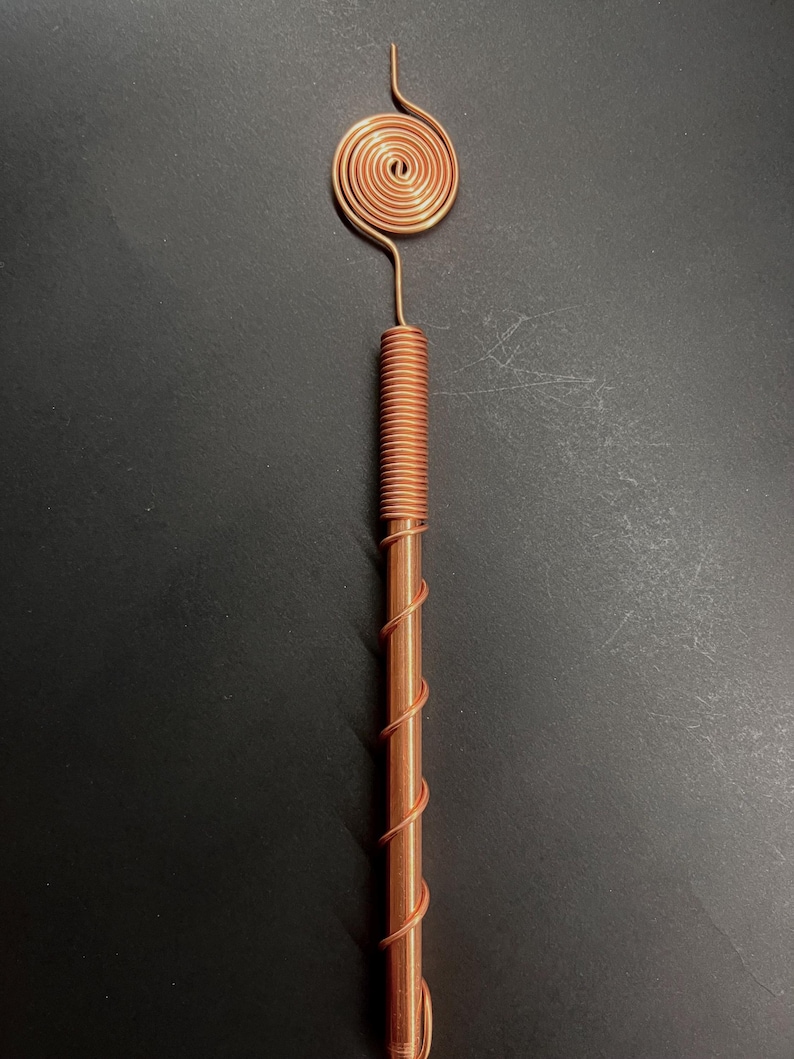 Macro view of copper spiral showing detailed winding and Tesla-inspired craftsmanship