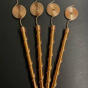 Three Tesla copper spiral antennas arranged for garden display photo