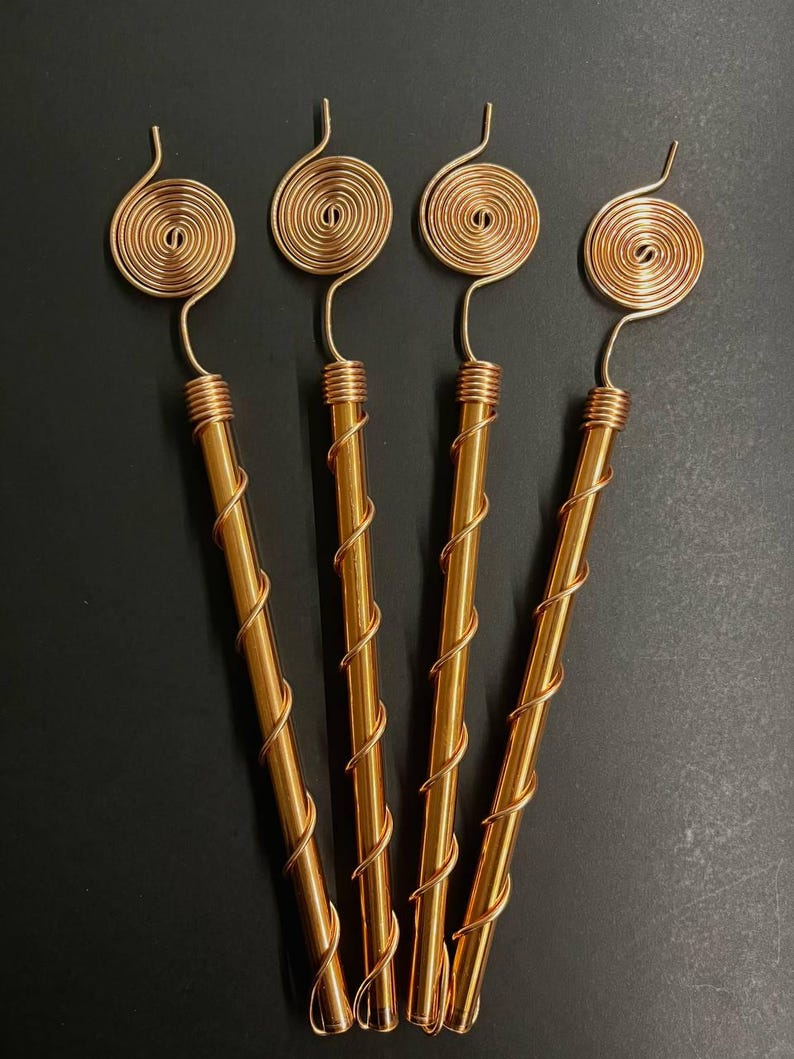 Three Tesla copper spiral antennas arranged for garden display photo