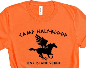Può includere: Maglietta arancione con una grafica nera di un cavallo alato e il testo "Camp Half-Blood Long Island Sound".